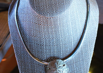 Silver sand dollar necklace.